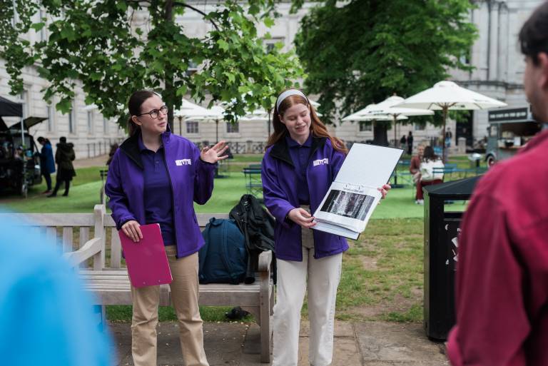 Two tour guides delivering material to the ӰԺ Walking Tour attendees