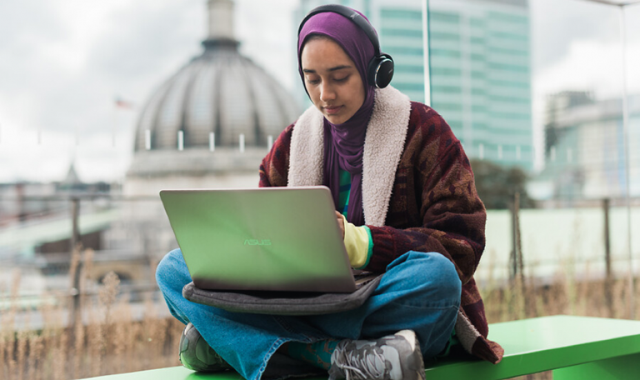 A student works on a laptop on the roof terrace of the ӰԺ students centre.